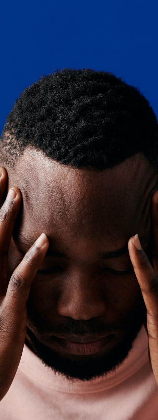 Photo of black man with his head in his hands